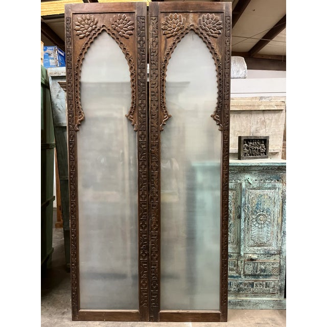 The scalloped Arch Door carved back and front, features a gracefully curved top, smoked glass and intricately carved...