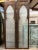 The scalloped Arch Door carved back and front, features a gracefully curved top, smoked glass and intricately carved...