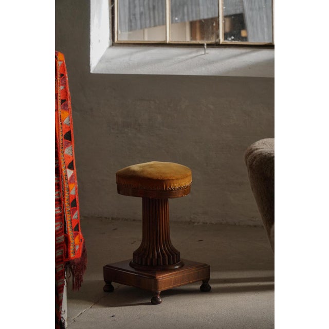 An elegant antique piano stool dating from around 1880, crafted in stained oak with a finely upholstered round seat. The...