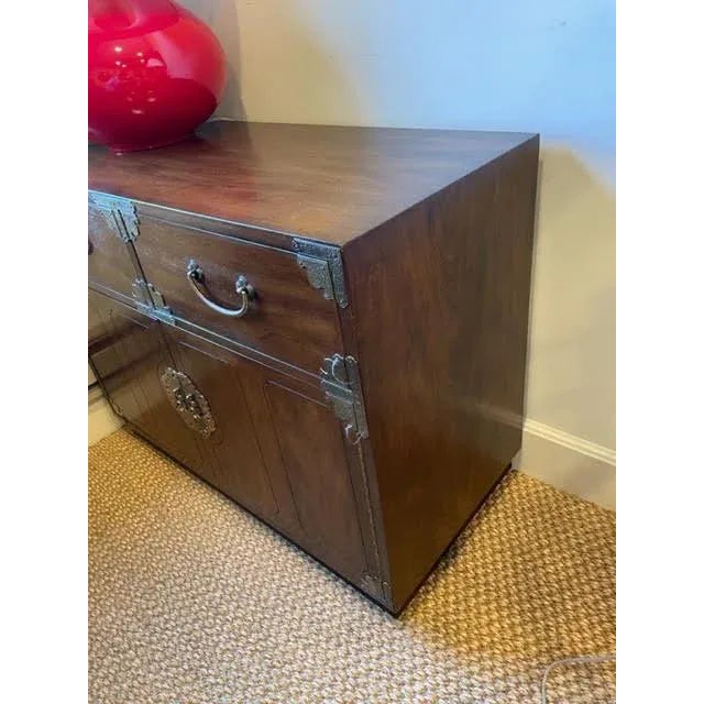Asian campaign chest with brass mountings. Two drawers at top and two doors below open to two shelves. Missing pins to...