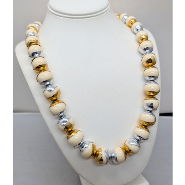 1980s Modernist ivory resin round beads with goldtone and rhodium plated "caps" single strand necklace with spring ring...