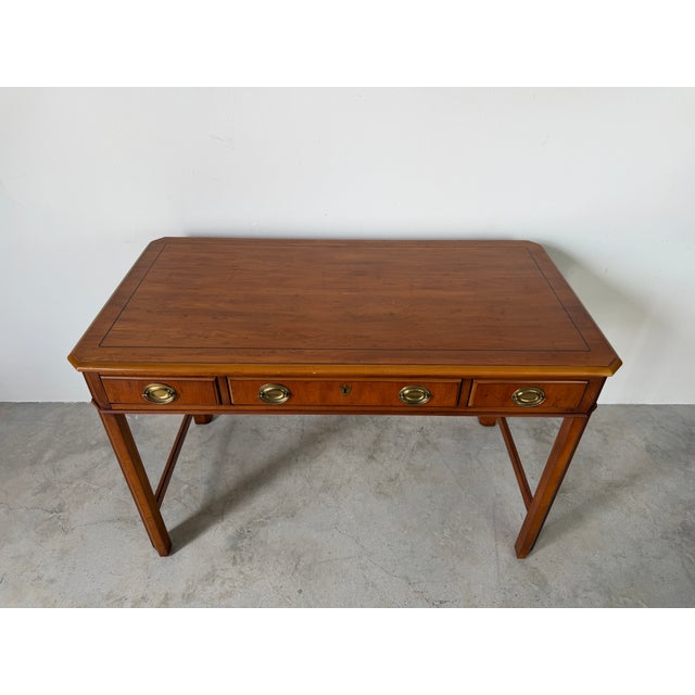 A beautifully crafted vintage Drexel writing desk featuring, elegant brass handles, and three drawers for ample storage....