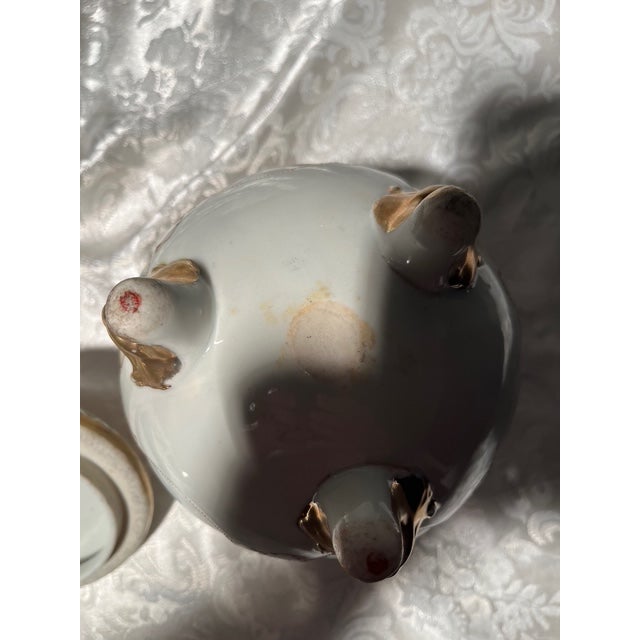 An exquisite mid-century Japanese Satsuma-style porcelain lidded jar. This piece features a striking tripod silhouette...