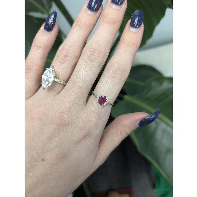 A stunning Solid 14K Gold ring featuring a vivid 7×5 mm oval Mozambique ruby elegantly accented with sparkling natural...