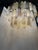 Luxury and scenographic contemporary chandelier made in Murano glass. Three levels of Murano glass “tronchi ” in champagne...