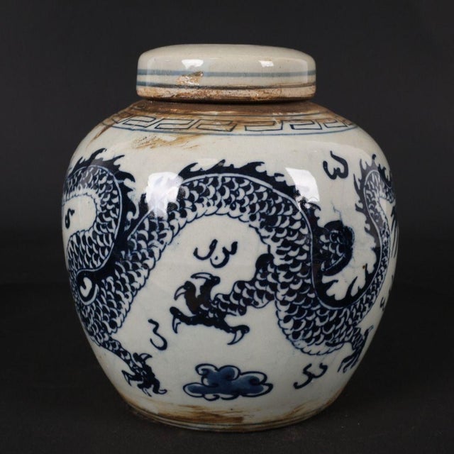 Beautiful Chinese chinoiserie lidded ginger jar decorated with a bold hand‑painted blue dragon motif against creamy white...