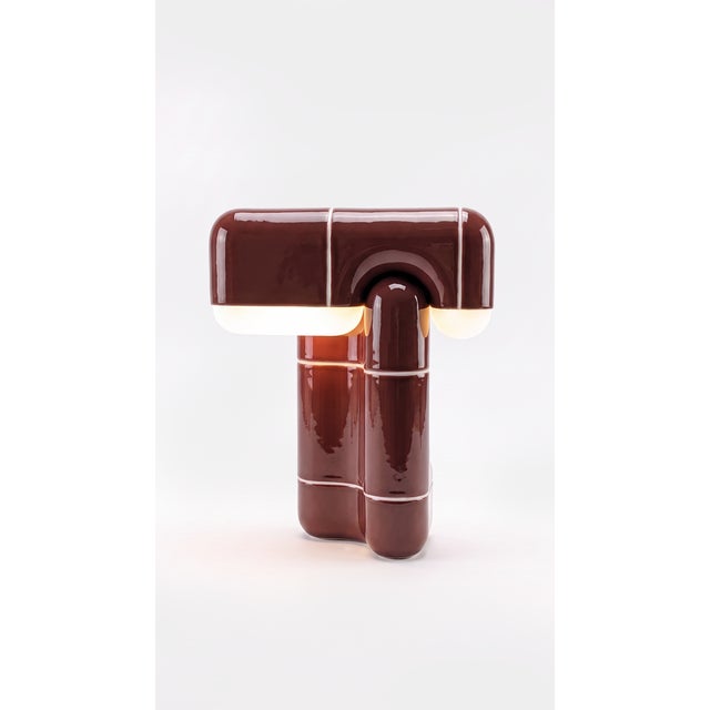 A table lamp that behaves like sculpture. Its folded, tile-built form reads as one continuous gesture, and when the light...