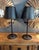 This industrial iron table lamp combines substantial cast-iron construction with sculptural form and beautifully aged...
