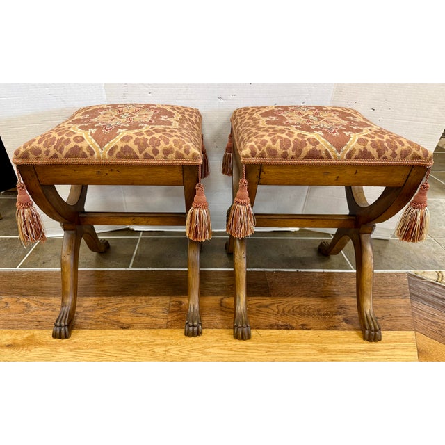 A striking pair of carved wood benches featuring sculptural X-form bases, shaped stretchers, and floral rosette carvings...