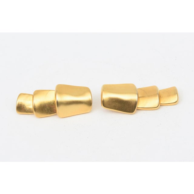 These beautiful pair of 1980's signed Robert Lee Morris gold plated earrings are tiered and sculptural. They pivot....
