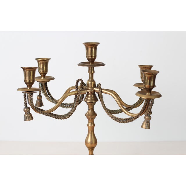 This vintage five-arm candelabra features an elegant ornate silhouette with draped rope and tassel detailing and a soft...