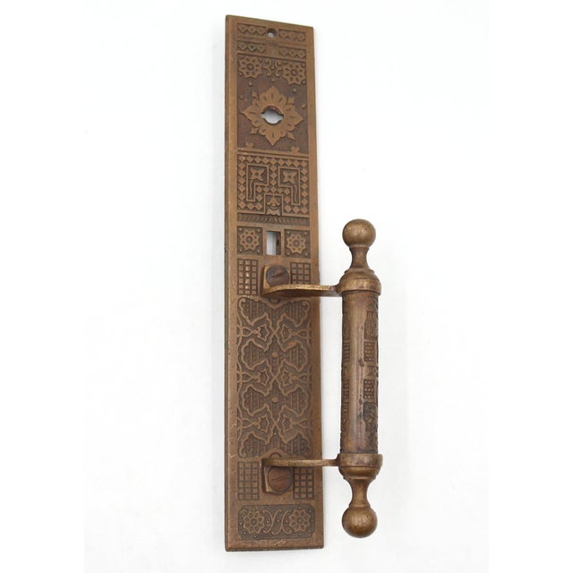 Antique door pull made of bronze with an ornate Aesthetic design, a missing thumb latch, and a lock insert. Made by...
