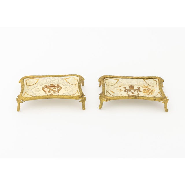 Group of Two French Gilt Metal and Porcelain Trinket Dish, footed tray, centered by crests, each signed "Jean" lower...