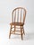 This antique Windsor style dining chair features a classic bow back silhouette with tall spindle supports, a shaped wood...
