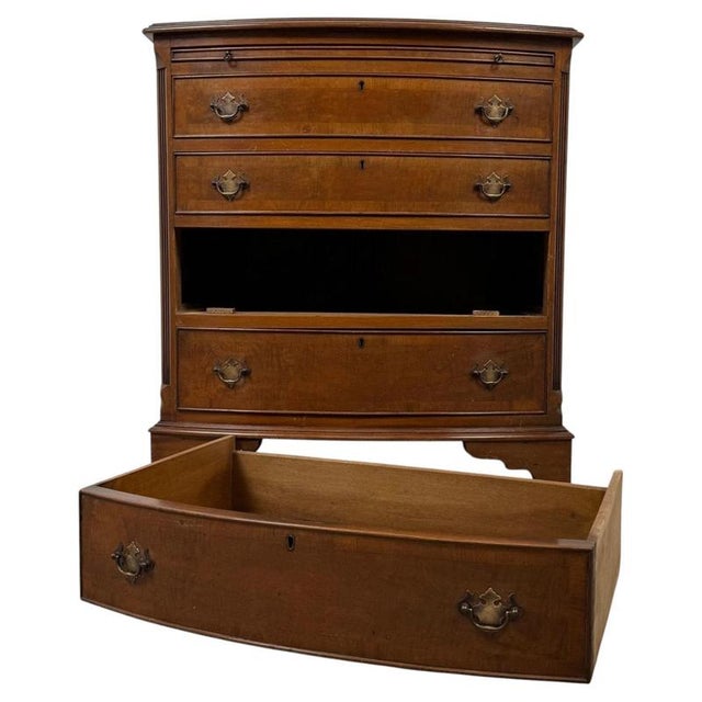 An elegant early 20th-century English chest of drawers, finely crafted in burr walnut and distinguished by its graceful...