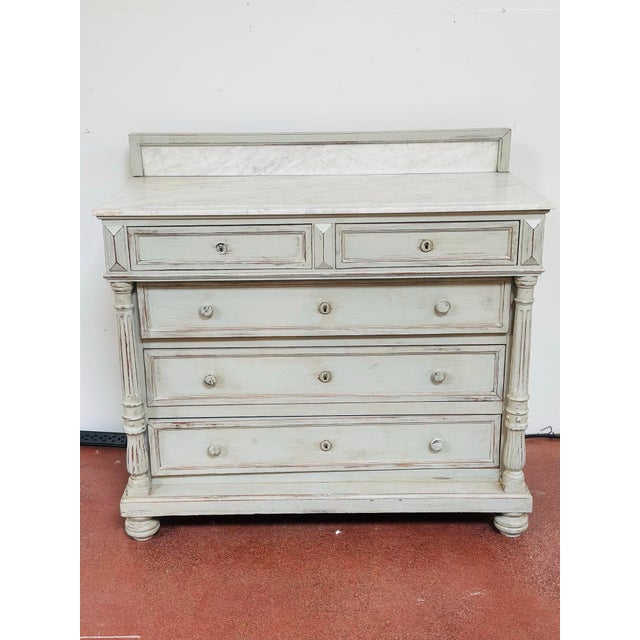 Antique marble-top chest of drawers featuring a beautifully aged painted finish with subtle distressing, fluted column...