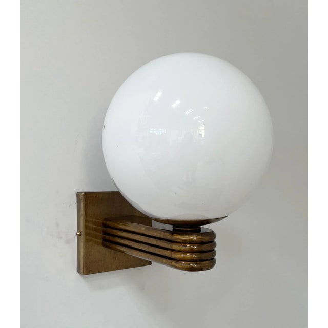 Italian Art Deco style wall light with Glossy White Murano glass globe mounted on Bronzed finish frame, designed by Fabio...