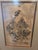 Framed Japanese figurative print depicting a traditionally dressed figure carrying swords, rendered in a dramatic ukiyo-e...