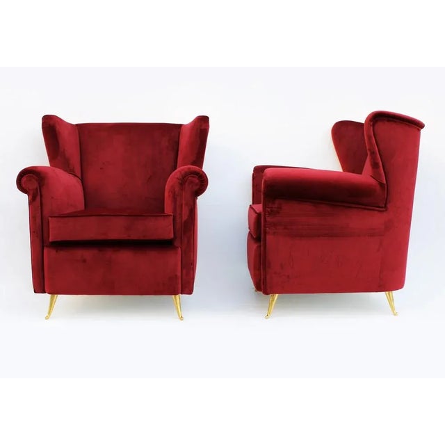 Particular pair of vintage armchairs with bordeaux velvet coating and brass feet Era: 1970 Dimensions: L82 x P70 x H90 x...