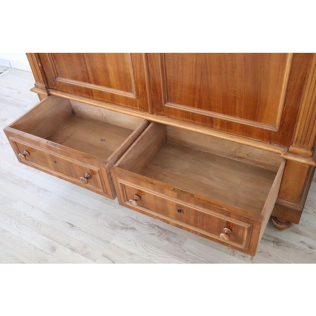 Antique Italian wardrobe in walnut veneer wood made in late 19th century. Very particular wardrobe characterized by a...