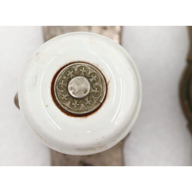 Antique door knob set with a white porcelain door knob and a nickel plated brass keyhole back plate. Made by Gilbert Lock...