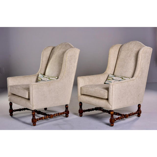 Pair of circa 1920s tall French winged armchairs with turned legs and stretchers, new off sand colored chenille velvet...
