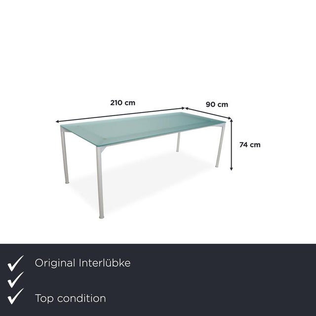 This desk boasts a remarkably minimalist design: a large, satin-finished glass top supported by four slender, powder-...