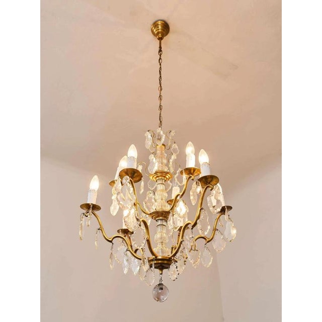 A beautiful chandelier in the subtle rococo style of louis xv. The body of the chandelier is made of polished brass and...