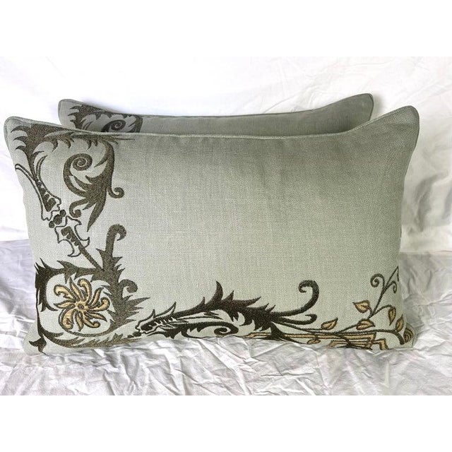 Pair of custom pillows featuring an elegant, embroidered linen by The Embroidery Palace. The embroidery showcases floral...