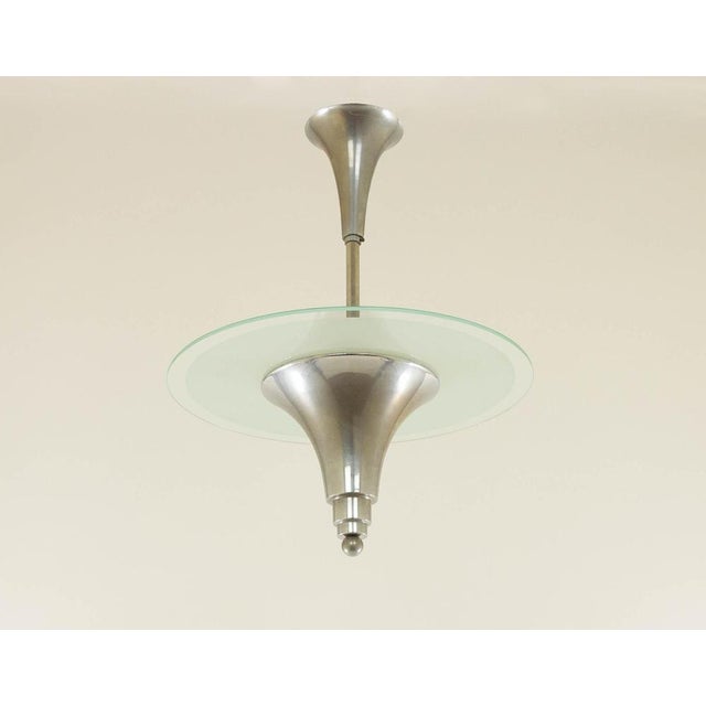 Characteristic Art Deco pendant light made of nickel and frosted glass; designed and manufactured in France around the...