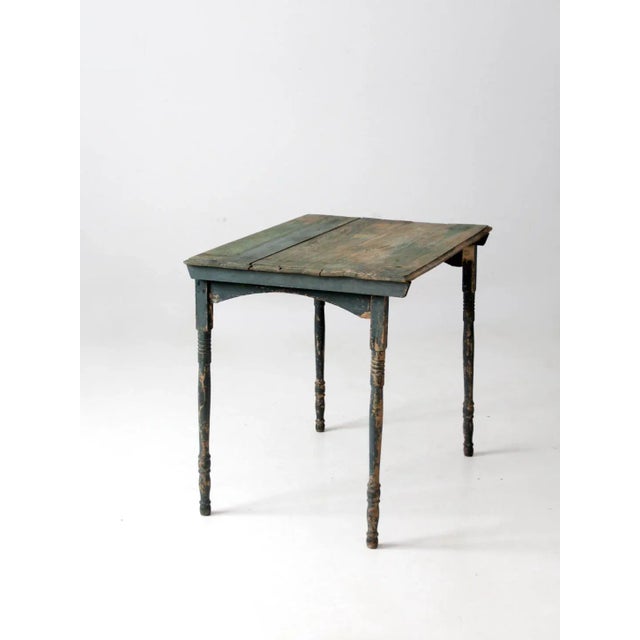 This is an antique "clipper" style painted folding table. The green wooden table has a turned legs. The wooden side table...