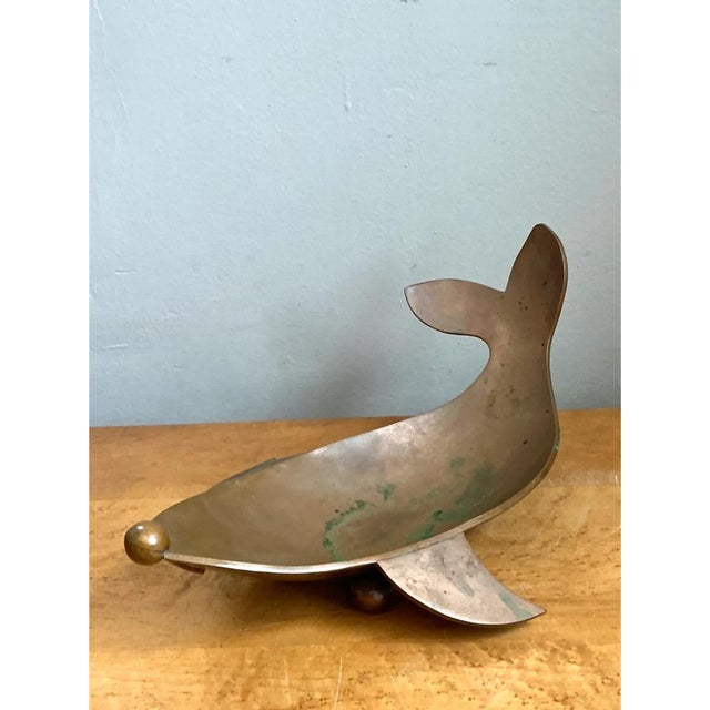 This vintage sculptural dish takes the whimsical form of a stylized whale, its body gracefully curved into a shallow,...