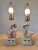 Antique German bisque figural base lamps, male and female figures with flower carts, pastel glazes.