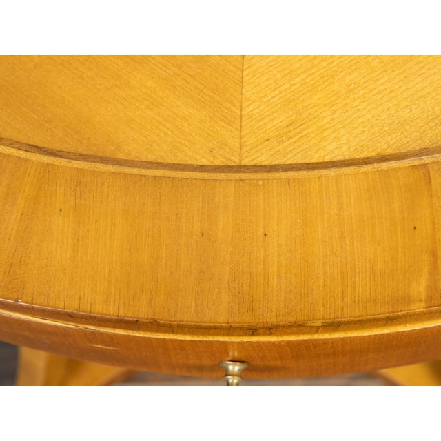 An Austrian Biedermeier period walnut accent table from the 19th century, with oval top, quarter veneer, banding, single...