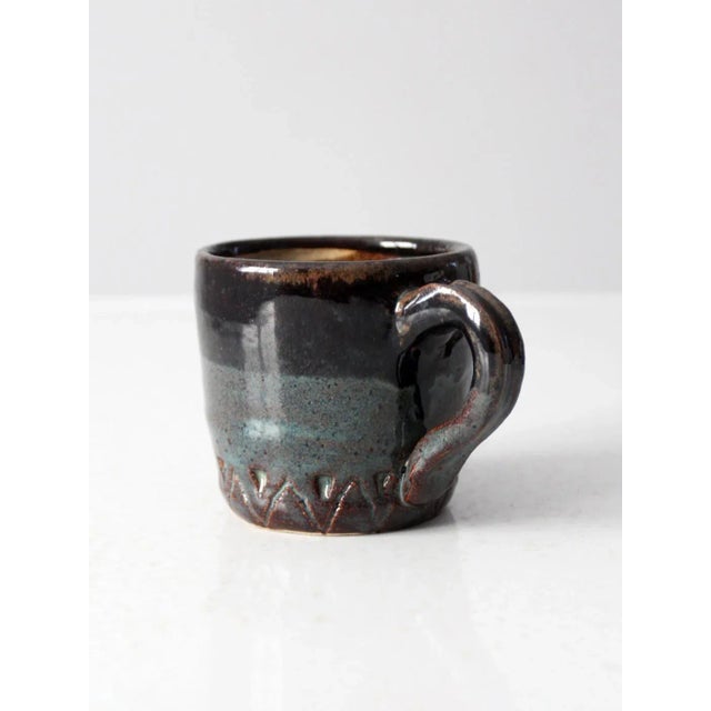 This is a vintage studio pottery mug. Signed by the artist, the handmade mug has a beautiful blue and dark brown drip...