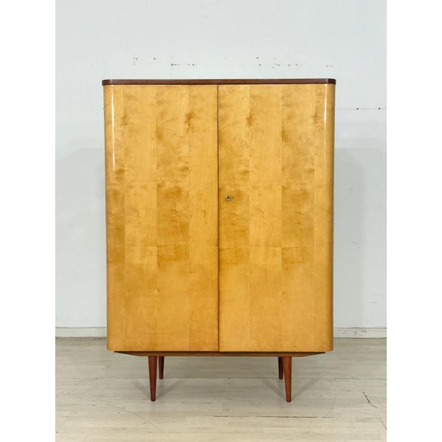 Beautiful, original vintage cabinet from the 1960s, distinguished by its elegant, two-tone design. The fronts gleam in a...