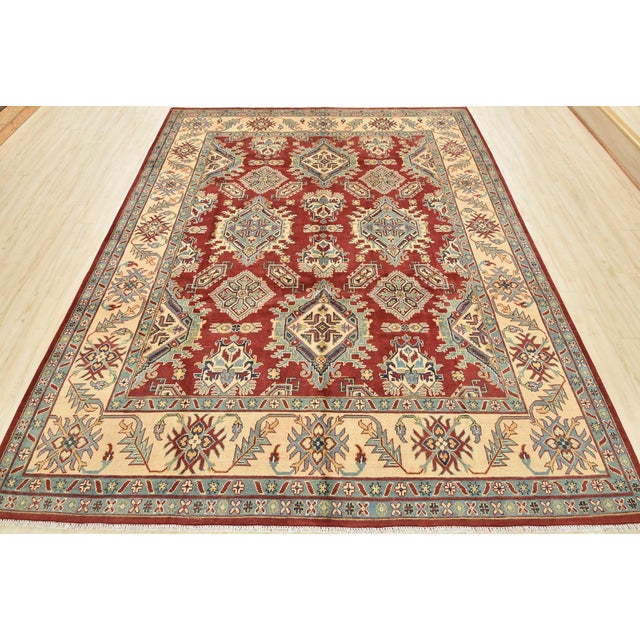 This traditional tribal geometric Caucasian Kazak rug is hand-knotted with an all-wool pile on a cotton foundation. This...