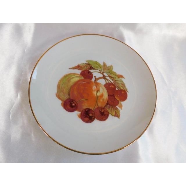 This is a set of four white fruit plates. Marked Japan. Each plate has a different fruit design on it done in reds and...