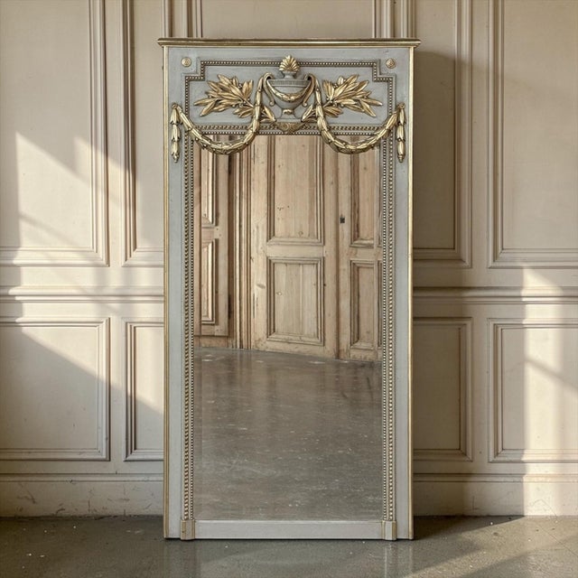 19th Century French Louis XVI Painted and Gilded Trumeau Mirror is an elegant in its restraint yet rich in classical...