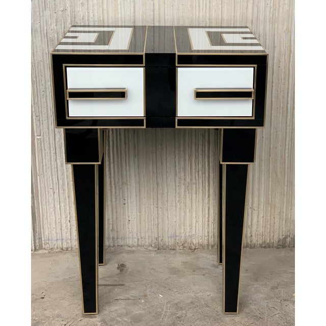 About New pair of mirrored and brass nightstands with one-drawer in black and white, 20th century Two glass handles...