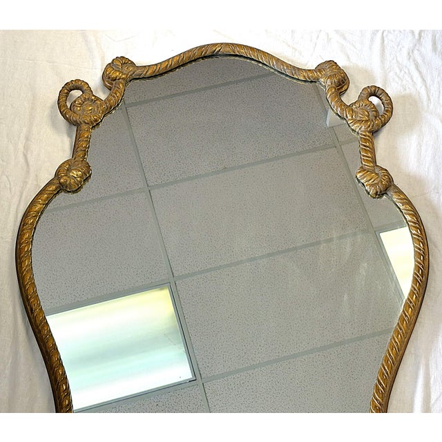 Striking large Hollywood Regency style wall mirror from the late 20th century. The piece is made of wood with an intricate...