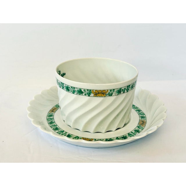 Vintage Haviland Limoges teacup and saucer set features a distinct "Calais Swirl" pattern in green and yellow fruits with...