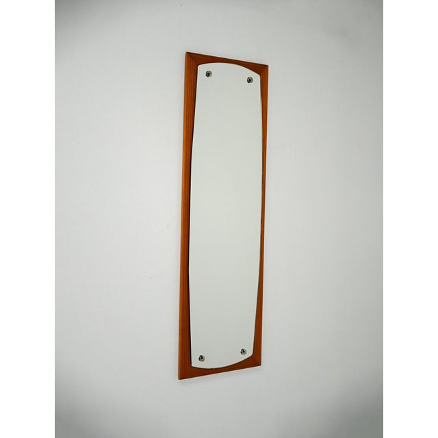 Scandinavian mirror from the 1950s with a shaped mahogany frame and exposed steel screws. An elegant Scandinavian wall...