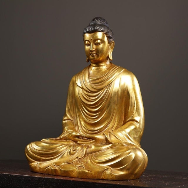 This is a finely crafted antique gilt bronze sculpture of a Tathagata Buddha, depicted in a serene meditative posture. The...