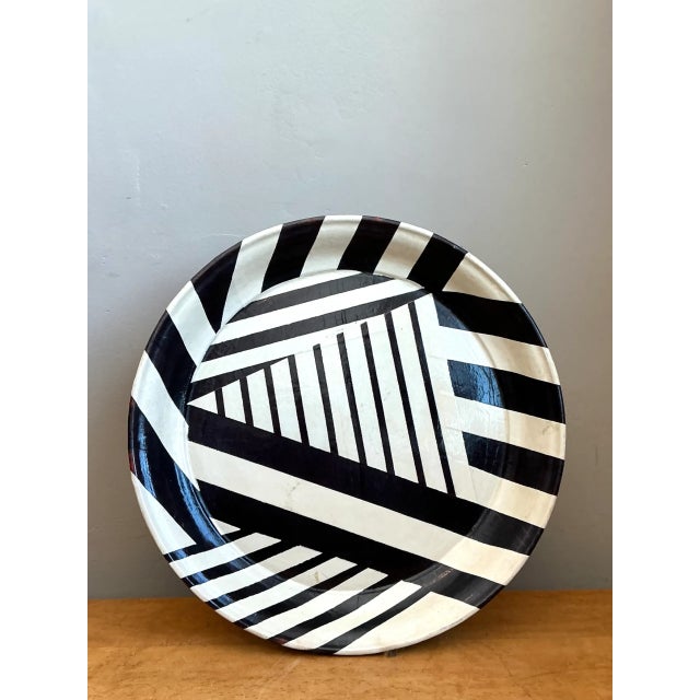 Defined by dynamic optical contrast and bold graphic angles, this vintage large round decorative tray features an eye-...
