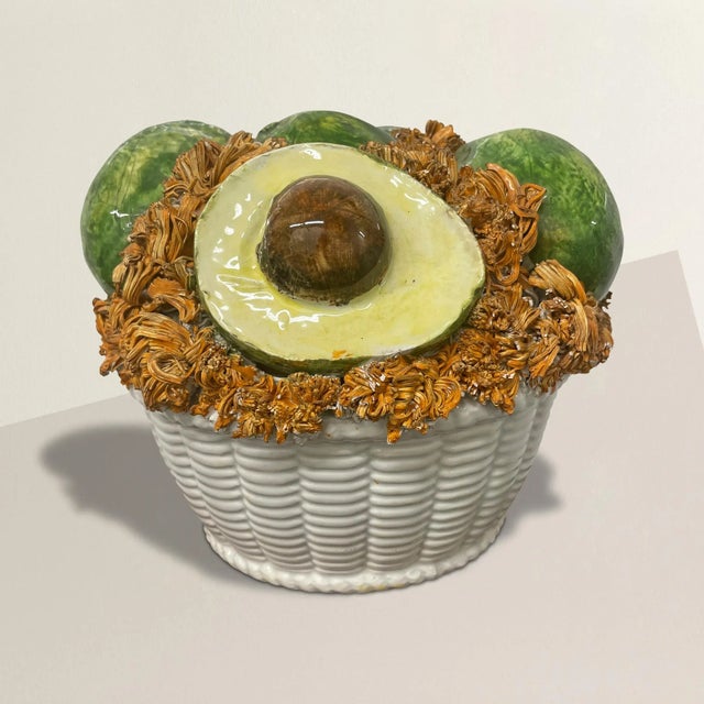A playful and whimsical mid-20th century Italian porcelain sculpture with five avocados, one cut in half with the pit...