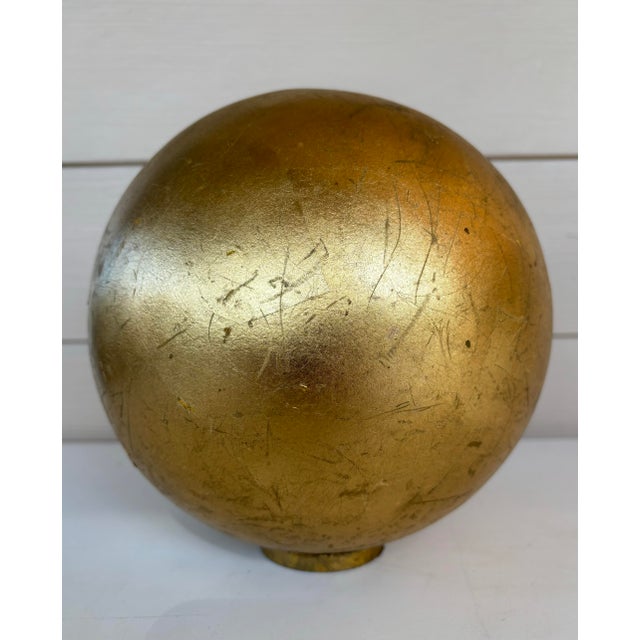 Gold leaf Sphere in the style of Mathias Goeritz on round gold leaf stand. The sphere measures 8” and weighs approximately...