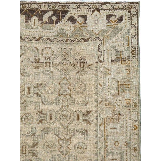 This early 20th-century Persian Malayer rug presents a finely balanced geometric composition in soft ivory, pale blue,...