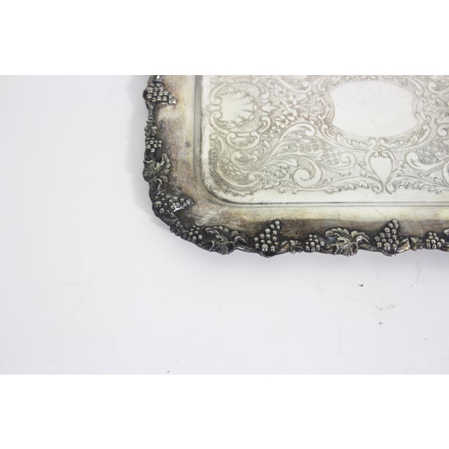 Small, rectangular vintage silver plated tray with raised grape detail around the edge and an embossed base. This is in...