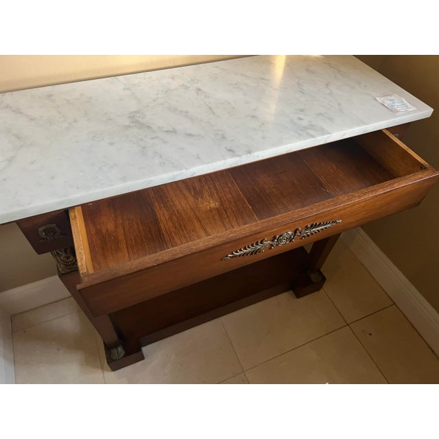 This French Empire style marble-top console tables with bronze mounts, mirror backs and plinth bases is a classic for any...
